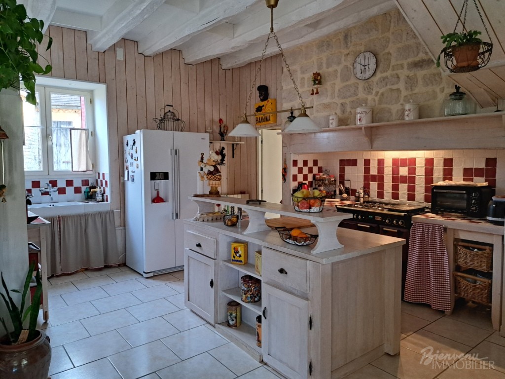 Bel ensemble en pierre, composé d’une charmante maison ancienne, avec véranda, de 2 belles granges avec atelier et garages, d’une piscine hors sol