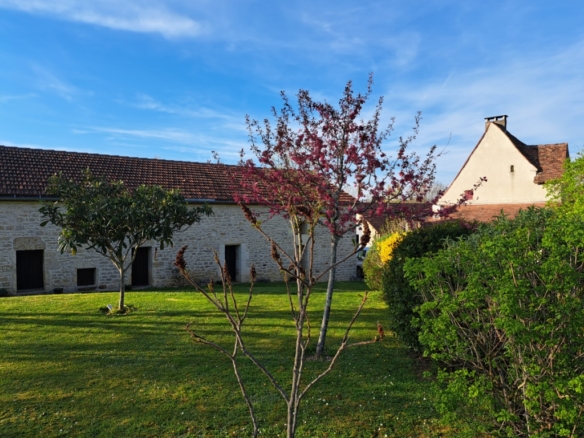 Bel ensemble en pierre, composé d’une charmante maison ancienne, avec véranda, de 2 belles granges avec atelier et garages, d’une piscine hors sol